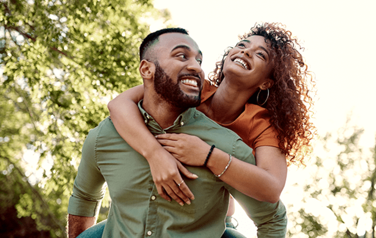 Man carrying smiling woman on his back