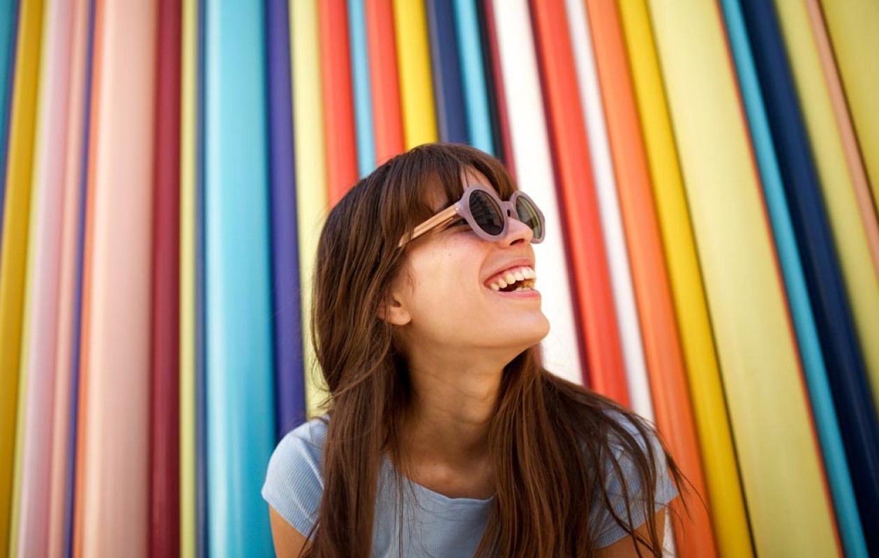 Woman smiling in front of a colorful wall