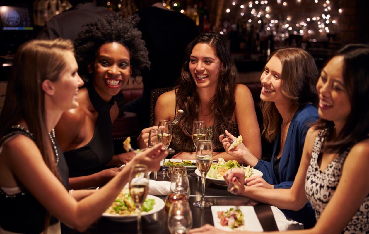 Five smiling women sitting around a party table