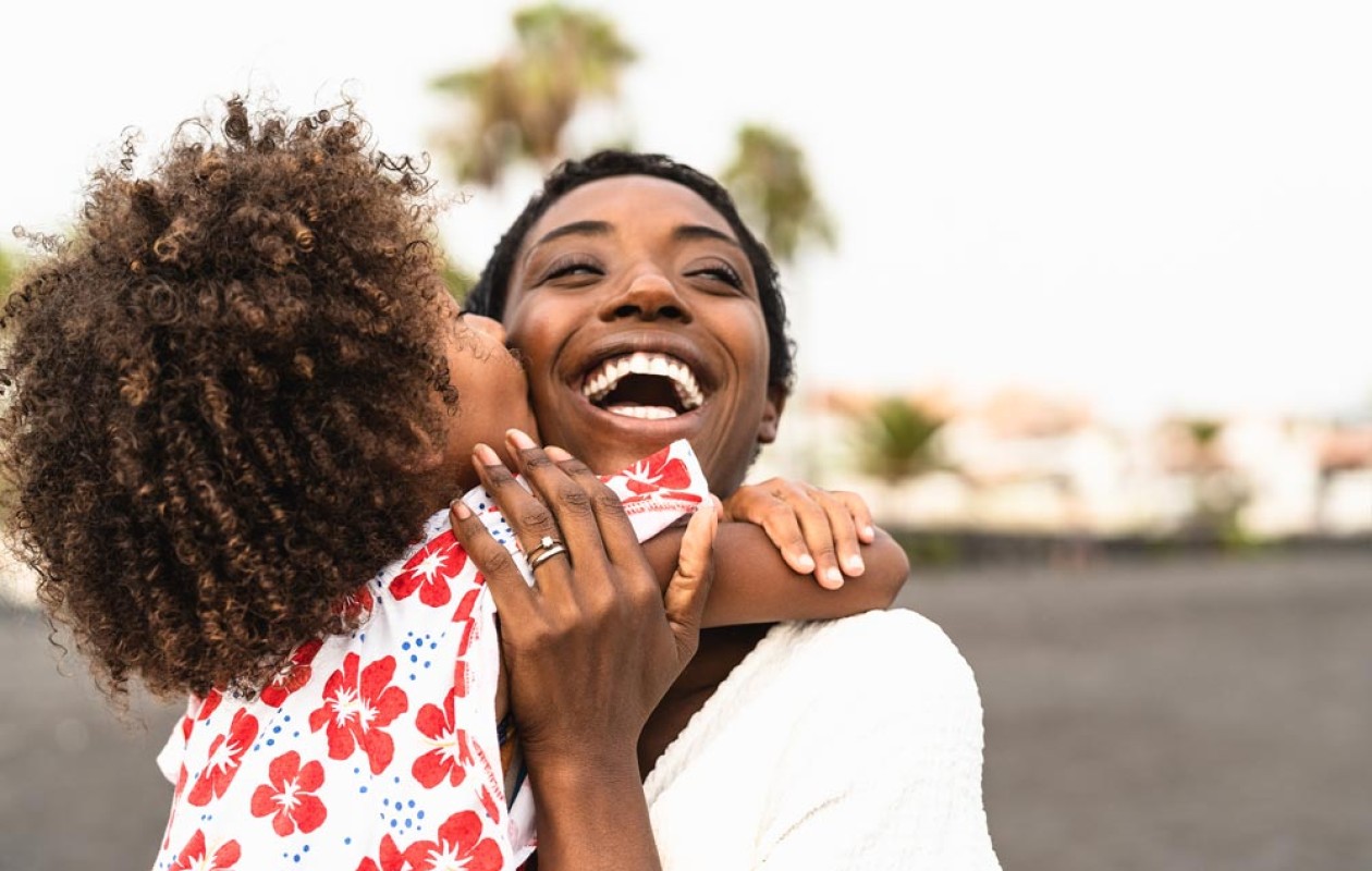 Little girl hugging and kissing a smiling lady