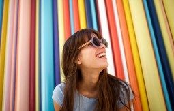 Woman smiling in front of a colorful wall