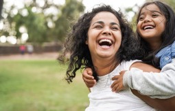 Girl smiling on woman's back