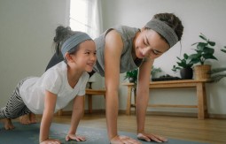 Daughter and mother doing yoga in a room
